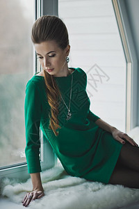 漂亮的女孩穿着长胸围穿着礼服绿裙子的女孩在窗帘4903上图片