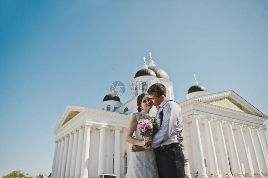 夫妻们站在白色柱子前丈夫和妻拥抱着第379号教堂的背景图片