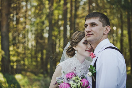 新婚夫妇拥抱着森林背景图片
