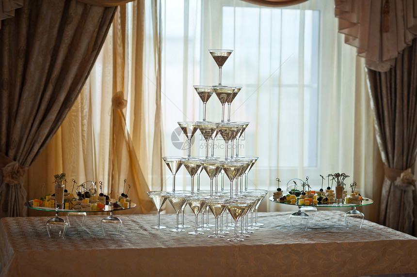 金字塔形的酒杯背景是香槟1562年金字塔里装满香槟的酒杯图片
