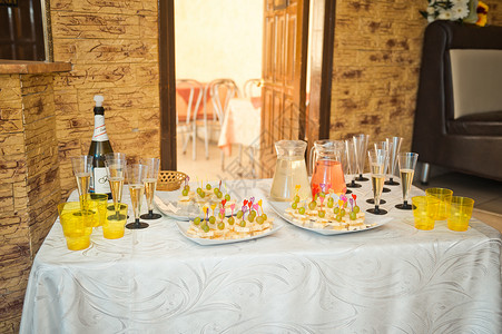 一个小桌子上面有香槟和零食162年假期开始时的餐桌上面有客人的零食图片
