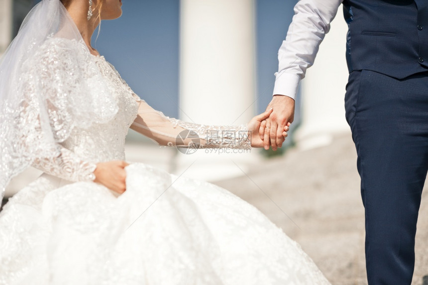 新郎手里握着娘的上握着婚礼的粉红色花束新郎手里握着娘的掌手握着2670图片