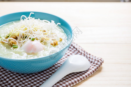 泰国大米粥烧猪肉和木桌上的勺子porkCongee图片
