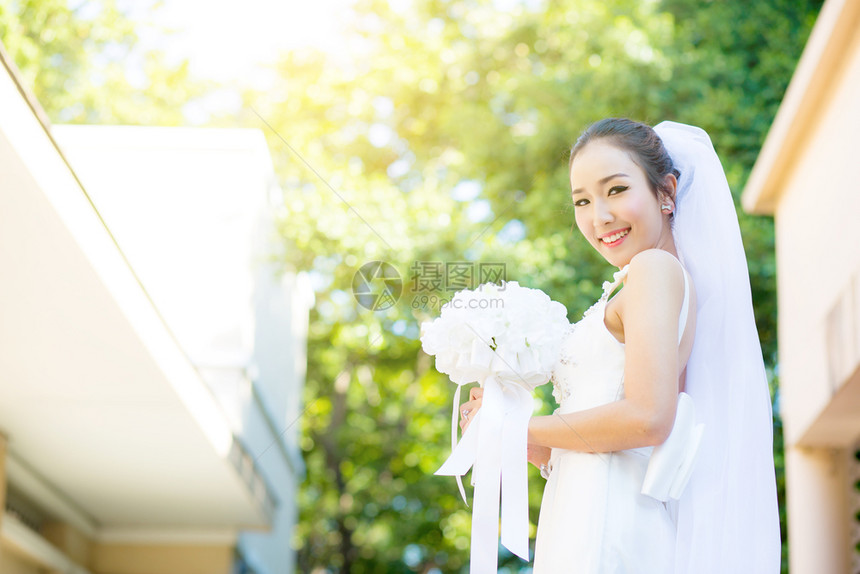 在婚礼当天美丽的年轻女子穿着白色礼服在花园里公的女肖像图片