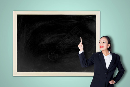 快乐的年轻商业女郎指着空的黑板图片