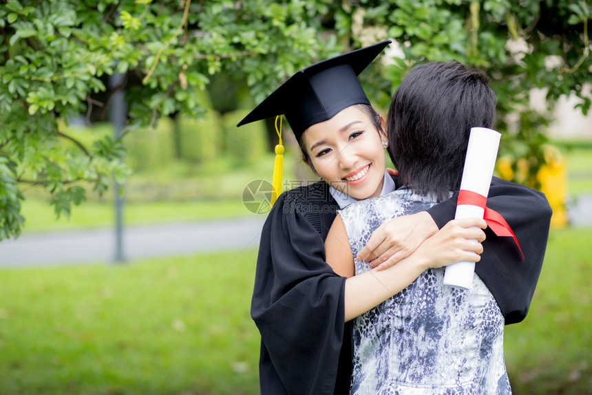 年轻的女毕业生在典礼上拥抱她的朋友图片