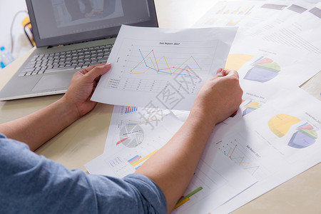 表中手持图和笔记本的金融纸面图表图片