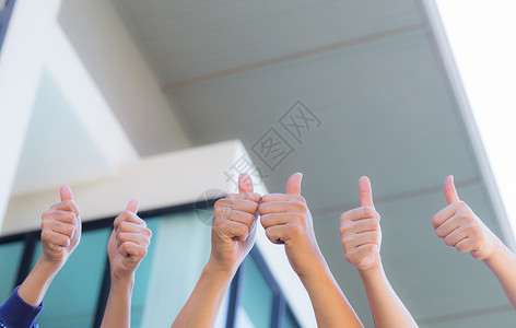 一群人的拳头举起拇指办公室背景团队合作业务概念图片