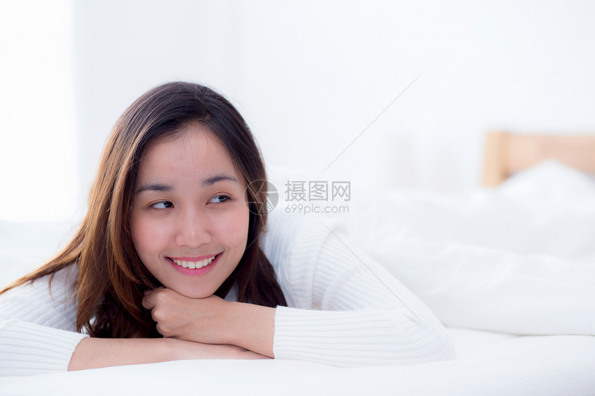 美丽的女人微笑着肖像在睡觉和躺床上后清晨醒来图片