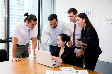 商业团队在会议期间使用笔记本电脑开会并介绍情况图片