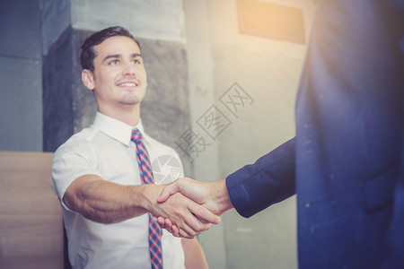 两个快乐成功的商业伙伴在办公室握手图片