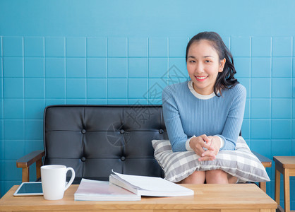 坐在沙发上的亚洲女人在客厅里枕着头图片