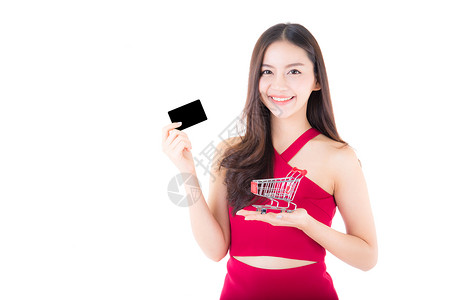 购物概念中的亚洲妇女孤立在持购物车和信用卡的白人背景女孩身上图片
