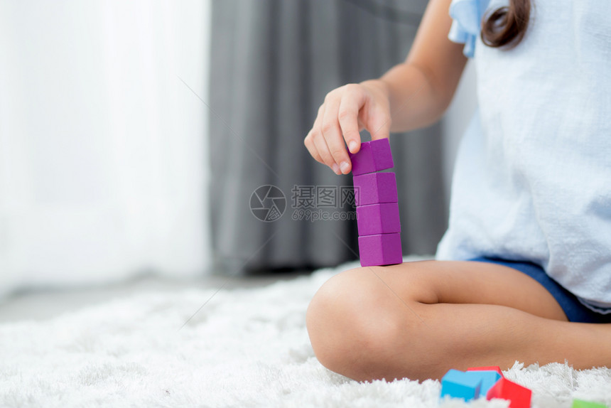 坐在地板上玩着多彩塑料块的亲手儿童早期向玩具学习如何成长图片