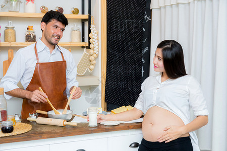 怀孕妻子的在厨房看做饭的丈夫图片