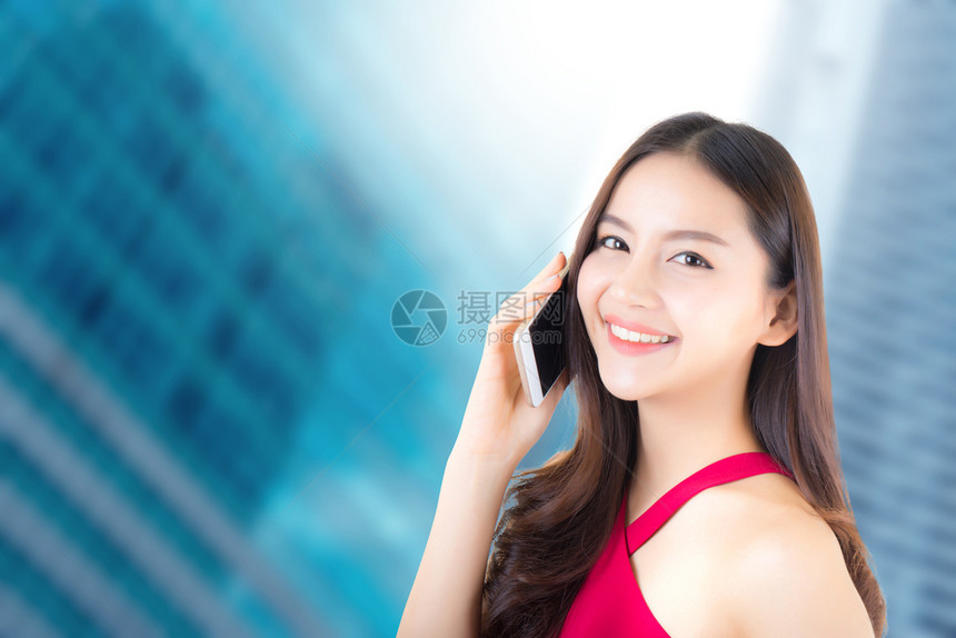 年轻美丽的亚洲女穿着红色礼服在智能手机上交谈在城市背景上快乐和成功交流商业概念图片