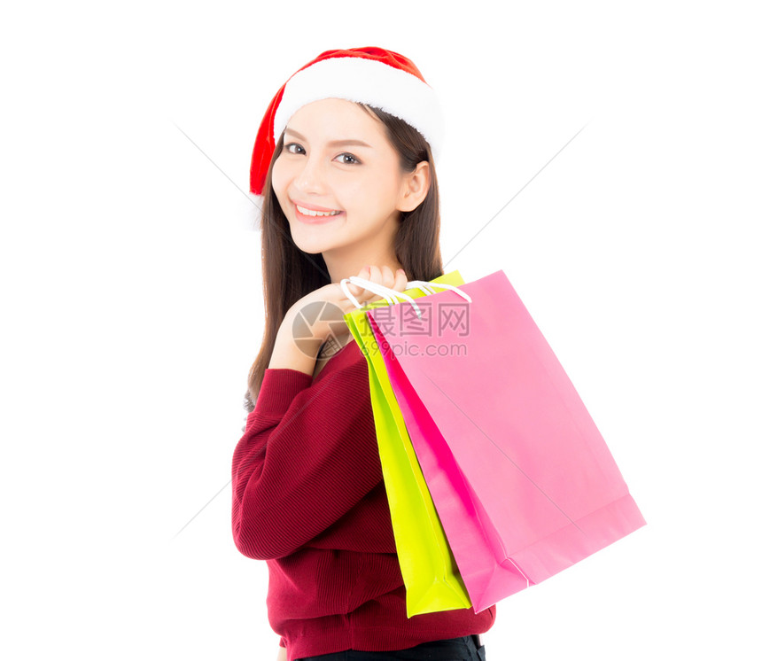 快乐的时尚女笑着拿购物纸袋销售和圣诞节与假日买家女孩享受并兴奋地孤立在白色背景上季节假日概念图片