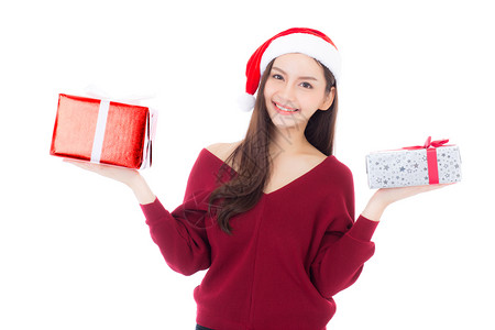 快乐的亚洲女人与微笑持有礼物盒xmas现今女孩与庆祝圣诞节一个假日女孩与买家隔离在白色背景购物与季节概念背景图片