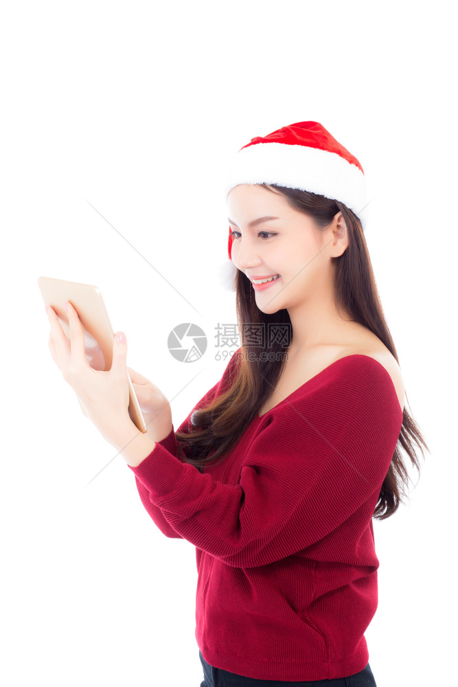 穿着红色礼服戴圣诞帽的美丽年轻女手持白衣的石板与色背景隔绝女孩与数字连接通信概念图片