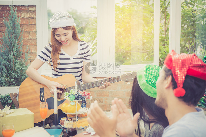 一群朋友聚会和弹吉他惊喜生日庆祝派对圣诞节和新年假日期概念图片