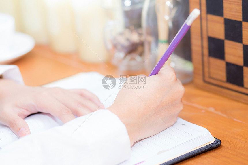 在桌子上的笔记本写字特妇女手孩在咖啡店用纸工作自由职业概念图片
