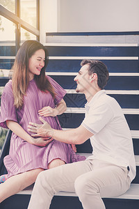男人听到妻子怀孕和英俊的父亲照顾母和夫妇期待母有一个幸福爱家庭概念图片