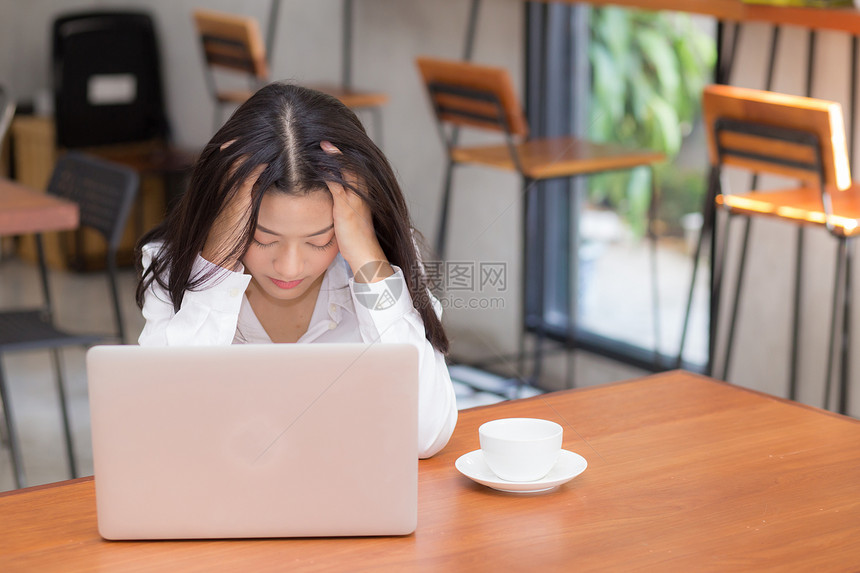 美丽的年轻女士工作思考问题压力和不快乐商业女人手持笔记本电脑桌面上情感自由职业商概念图片