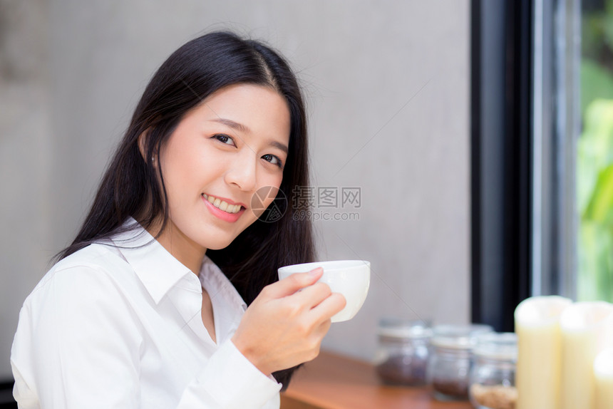 美丽的年轻女在咖啡馆喝早上微笑女孩坐在咖啡店吃早餐图片