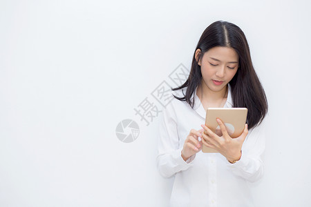 美丽的肖像年轻女使用平板电脑水泥背景商业妇女坐着看平板电脑通信概念图片