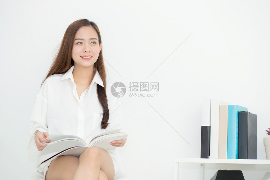 美丽的亚洲年轻女微笑着快乐阅读一本书女孩休闲与杂志教育概念图片