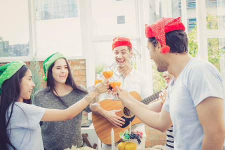 一群朋友聚会和弹吉他惊喜生日庆祝派对圣诞节和新年假日期概念背景图片