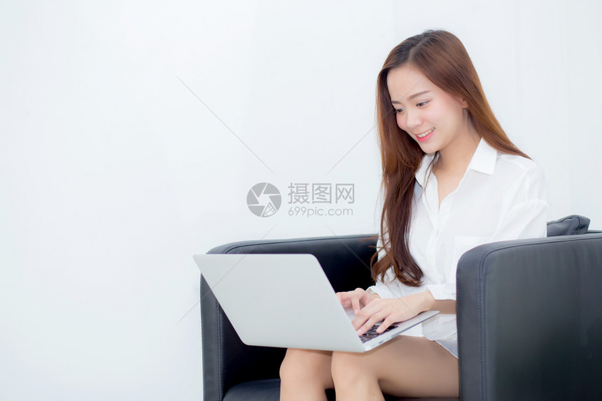 使用笔记本电脑在沙发上闲暇女孩在网上与笔记本自由职业者合作图片