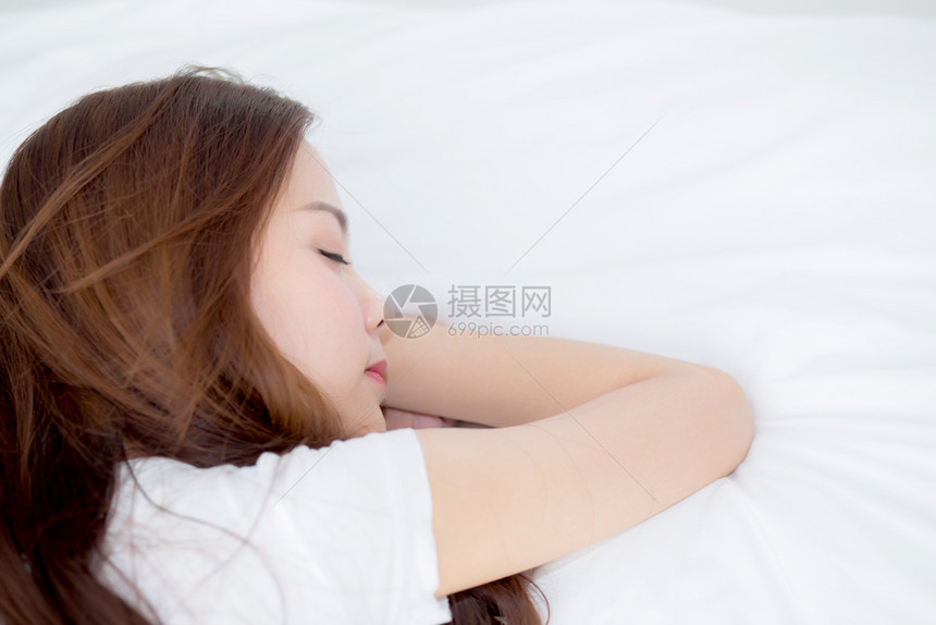 美丽的亚洲年轻女子睡在床上头躺枕舒适享受休闲女孩对健康和生活方式概念放松高观图片