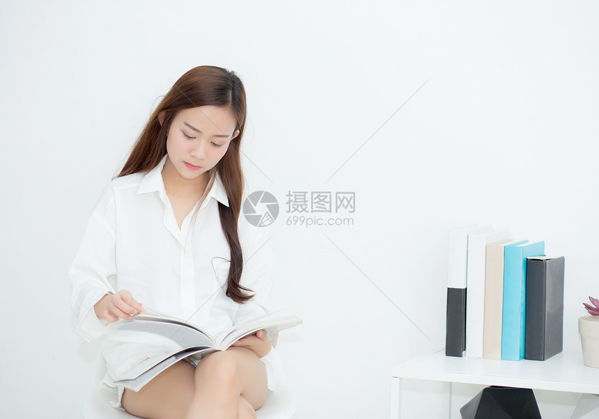 美丽的亚洲年轻女微笑着快乐阅读一本书女孩休闲与杂志教育概念图片