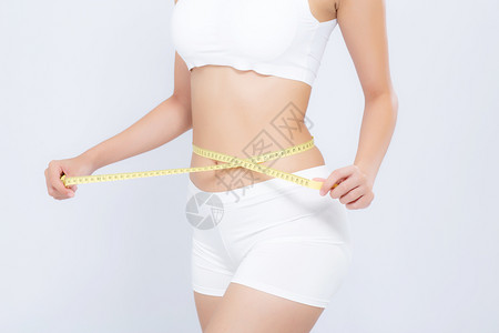 亚洲妇女的饮食和体瘦腰部尺寸与白色背景的体重隔绝女孩用胶带测量健康和概念丧失了纤维素和卡路里背景图片