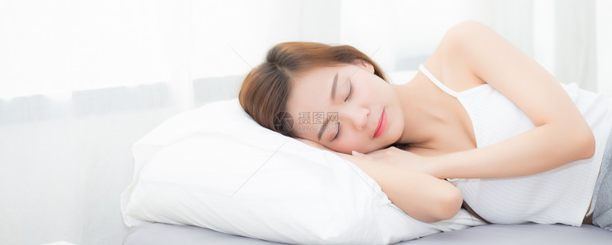 睡在床上头躺枕舒适而快乐图片