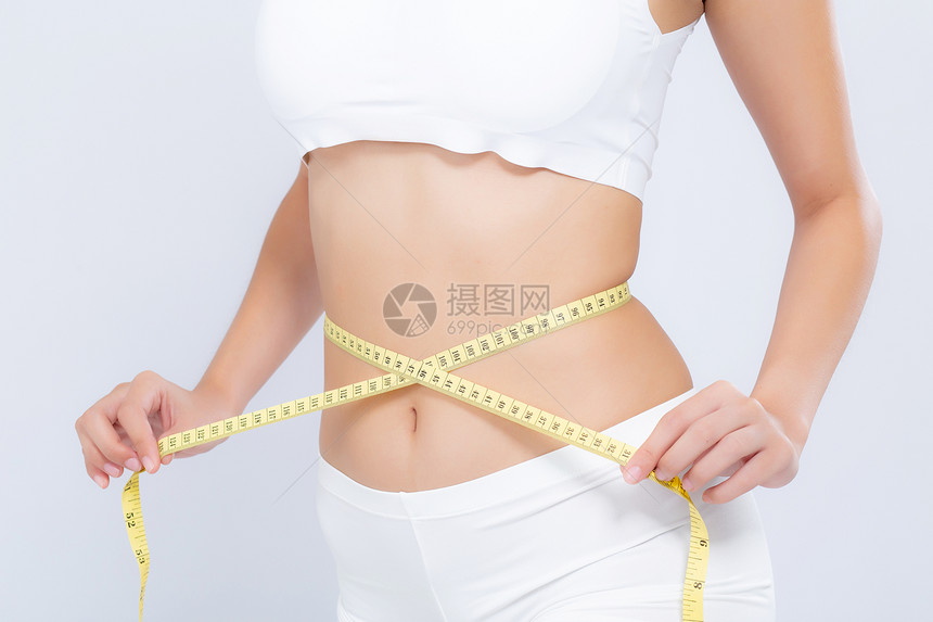 亚洲妇女的饮食和体瘦腰部尺寸与白色背景的体重隔绝女孩用胶带测量健康和概念丧失了纤维素和卡路里图片