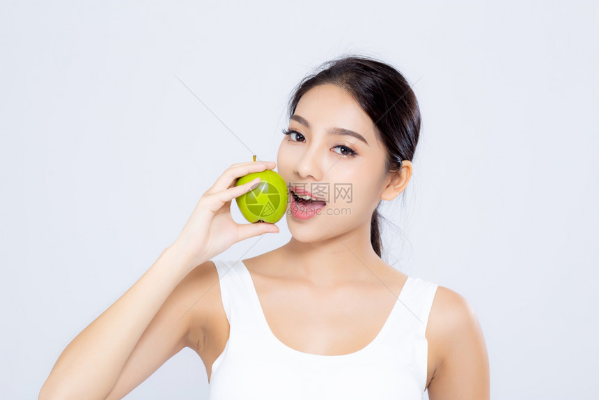 肖像的亚洲妇女微笑地抱着和吃绿色苹果水和美丽的身体饮食与白种背景隔绝女孩体重瘦有纤维素或卡路里健康和概念图片