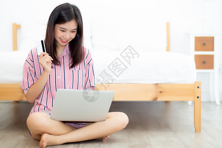 包括笔记本电脑网上购物内容女孩在卧室床上用笔记本电脑付款生活方式概念图片