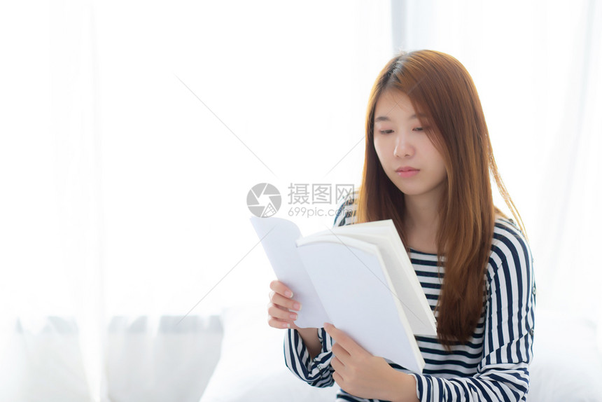 美丽的肖像年轻亚洲女放松坐在家里卧室的阅读书女孩学习文教育和生活方式概念图片