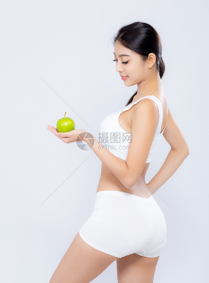 长生不老的亚洲妇女笑着拿绿苹果水和美丽的身体饮食图片