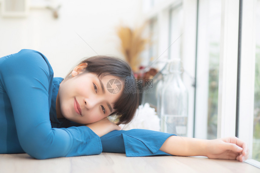 美丽的肖像年轻亚洲女人微笑坐在咖啡馆里模范女孩快乐的放松休息着看相机生活方式的概念图片