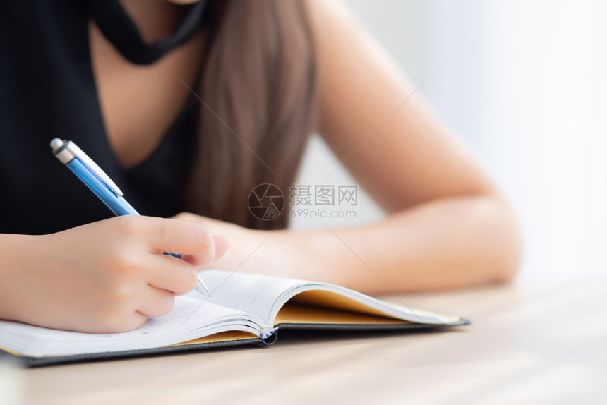 坐在家中客厅桌边学习写笔记本和日女童功课在桌边工作的商业家妇女教育概念图片