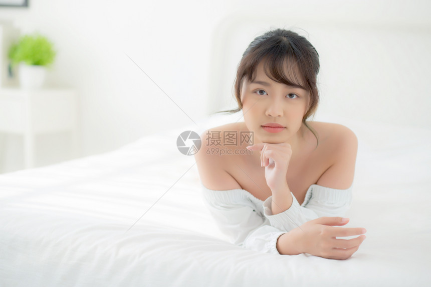 美丽的肖像年轻亚洲女人躺着笑早上醒来清晨日出美丽可爱的女孩快乐地躺在床上睡卧室里图片