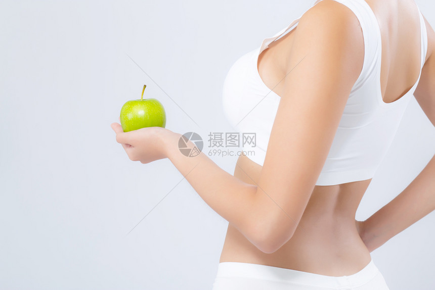 背面肖像是一位女持有绿苹果水和美丽的身体饮食与白色背景隔绝图片