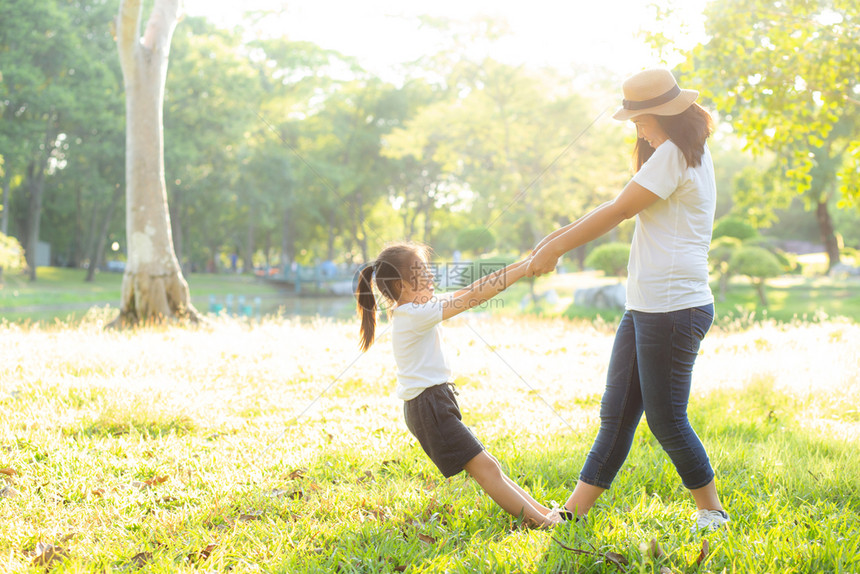 年幼的亚洲母亲和小女儿在公园玩耍乐和幸福家庭享受放松和闲暇母亲孩子在夏天笑起来图片