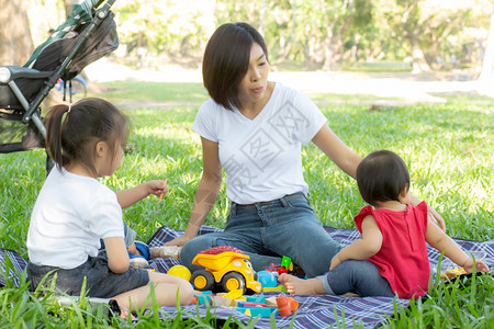 一起趣打卡美丽的年轻幼母亲和女儿在夏季公园玩具弄学习成长的快乐和趣母亲孩子一起在花园玩乐活动假期家庭概念背景