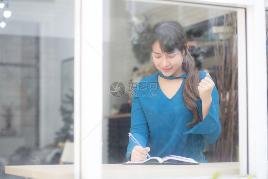年轻的亚洲女作家写在笔记本或日记上的美丽肖像快乐和兴奋生活方式亚洲女孩规划工作和成功教育和商业理念图片