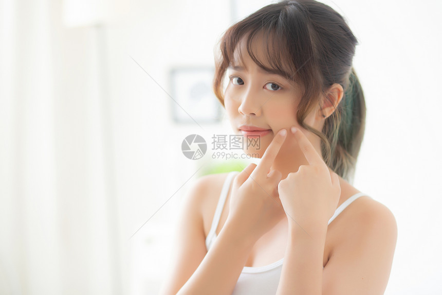 美丽的肖像年轻女卧室有肛门问题脸部美容青春治疗Asia女孩是小便担心和不高兴皮肤护理和健康的概念图片