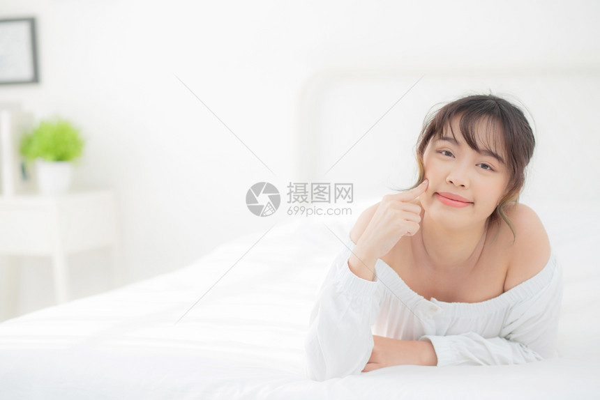 美貌丽的年轻女微笑早上在卧室醒来健康美貌女孩躺在皮肤上图片